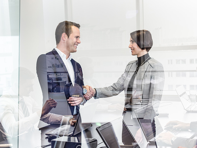 Business people shaking hands in moder corporate office.